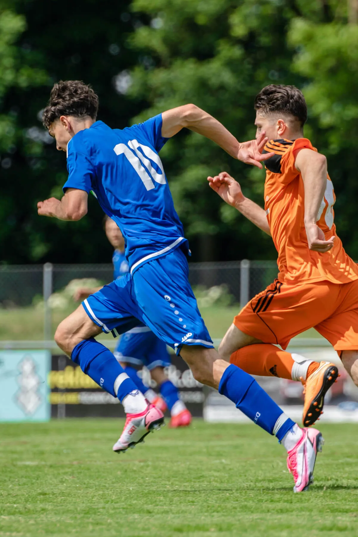 Two football players running on the football field.
